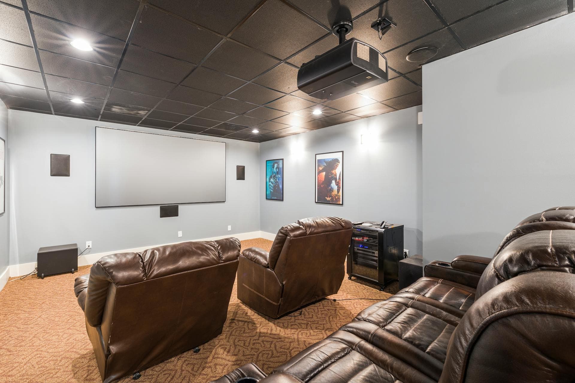 A large home cinema with projector and reclining chairs