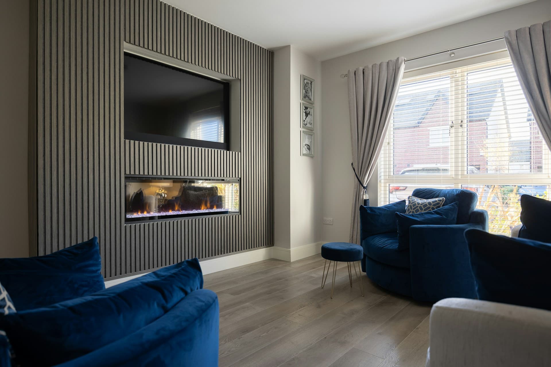 A lounge with a TV set into the wall above a fireplace